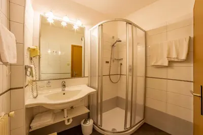 a bathroom with a sink and a shower at Hotel Mehrhauser in Nalles