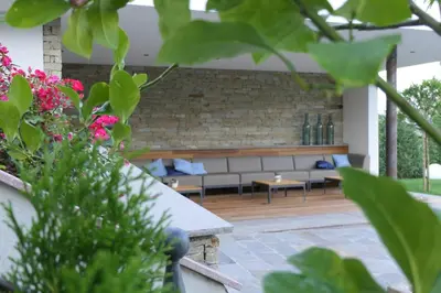 a patio with a couch and tables and flowers at B & B Gurterhof in Schenna