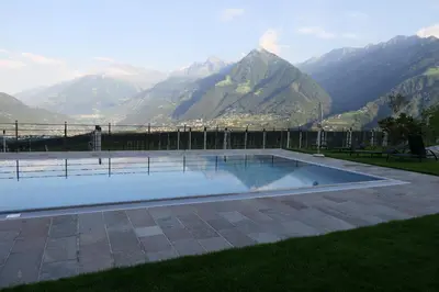 a swimming pool with a view of mountains at B & B Gurterhof in Schenna