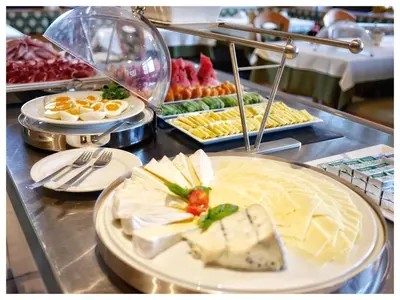 a buffet with cheese and other food on a table at B & B Gurterhof in Schenna