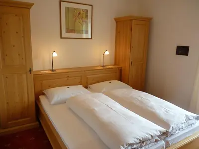 a bed with two white pillows and two lamps at B & B Gurterhof in Schenna