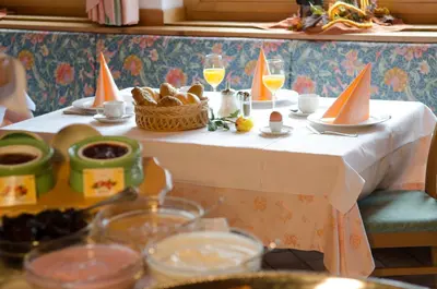 a table with food and orange hats on it at Pension Felseneck in San Leonardo in Passiria