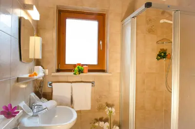 a bathroom with a sink and a shower at Pension Felseneck in San Leonardo in Passiria