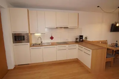 a kitchen with white cabinets and a wooden counter top at Residence Sonnberg in Perca