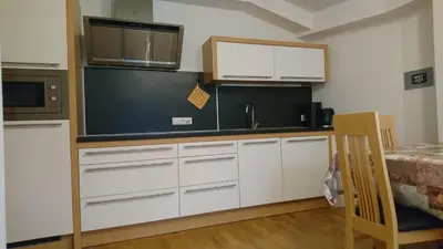 a kitchen with white cabinets and a black wall at Residence Sonnberg in Perca