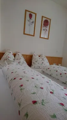 a bed with a floral bedspread and two pictures on the wall at Residence Sonnberg in Perca