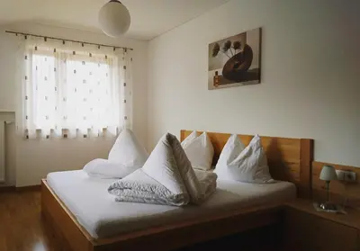 a bedroom with a bed with white pillows and a window at Residence Sonnberg in Perca