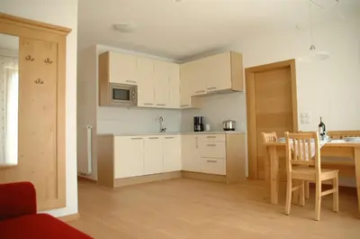 a kitchen with white cabinets and a wooden table at Residence Sonnberg in Perca