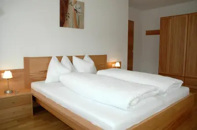a bedroom with a white bed with white sheets at Residence Sonnberg in Perca
