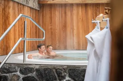 a man and a woman in a hot tub at Hotel Jägerheim 3S in Selva di Val Gardena