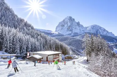 a group of people skiing down a snow covered mountain at Hotel Jägerheim 3S in Selva di Val Gardena