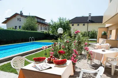 a table with fruit on it next to a pool at Pensione Penegalblick in Appiano sulla Strada del Vino