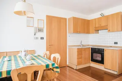 a kitchen with a table and chairs in a room at Residence Dolomia in Pozza di Fassa