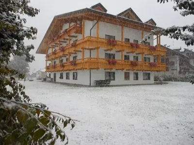 a large building with snow in front of it at Residence Dolomia in Pozza di Fassa