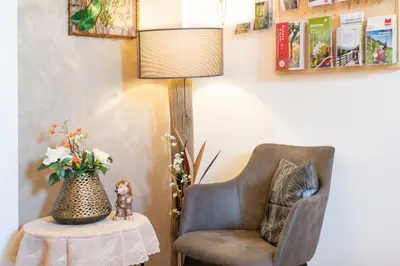 a room with a chair and a table with a lamp at Ferienwohnungen Lanserhof in Appiano sulla Strada del Vino