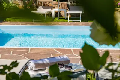 a pool with a towel and sunglasses next to a pool at Ferienwohnungen Lanserhof in Appiano sulla Strada del Vino