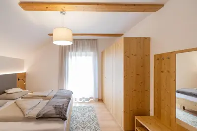 a bedroom with two beds and a window at Ferienwohnungen Lanserhof in Appiano sulla Strada del Vino