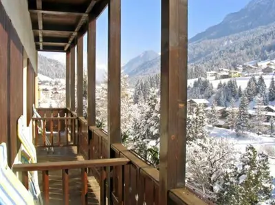 a balcony with a view of a town and mountains at Hotel Val Di Fassa in Soraga