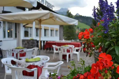 a room with tables and chairs with pink tablecloths at Hotel Val Di Fassa in Soraga