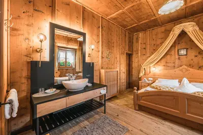 a bathroom with a bed and a sink in a room at Ansitz Zehentner in Laion