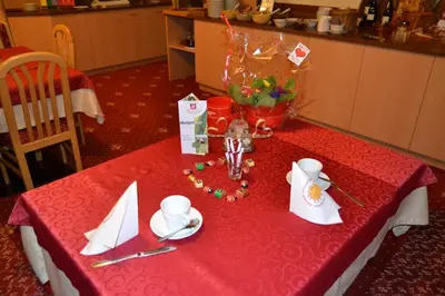a table with a red table cloth with napkins on it at Häuslerhof in Maranza