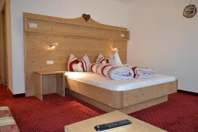 a bed with red and white pillows on it at Häuslerhof in Maranza