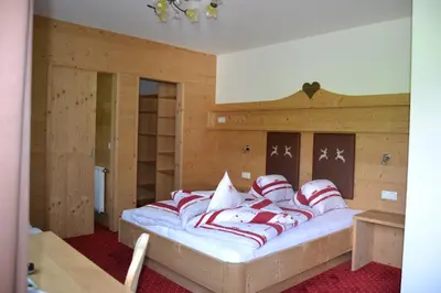 a bed with red and white pillows in a room at Häuslerhof in Maranza