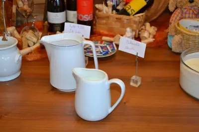 two white coffee mugs sitting on a wooden table at Häuslerhof in Maranza