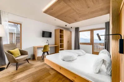 a bedroom with a bed and a chair and a desk at Hotel Pfeiferhof in Maranza
