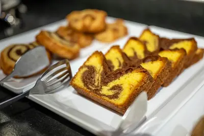 a white plate with a piece of cake and pretzels at Hotel Pfeiferhof in Maranza