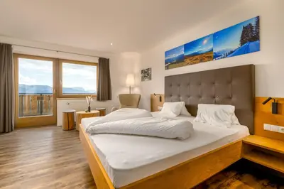 a bedroom with a large bed and a large window at Hotel Pfeiferhof in Maranza