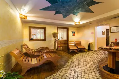 a living room with benches and a star ceiling at Hotel Salvan in Campitello di Fassa