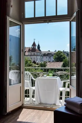 a table and chairs on a balcony with a view at Hotel Kolping in Merano