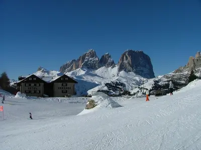 a group of people skiing down a snow covered mountain at Hotel Garni Gonzaga in Canazei