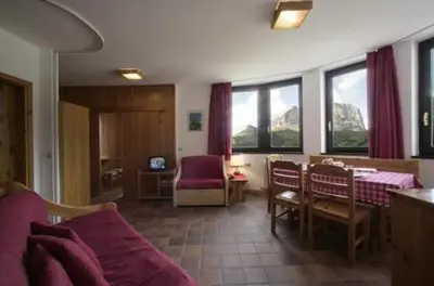 a living room with a couch and a table and chairs at Hotel Garni Gonzaga in Canazei