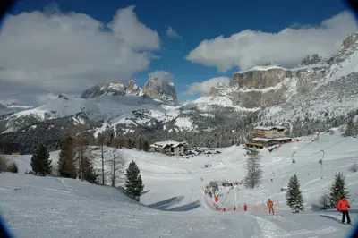 a group of people skiing down a snow covered mountain at Hotel Garni Gonzaga in Canazei