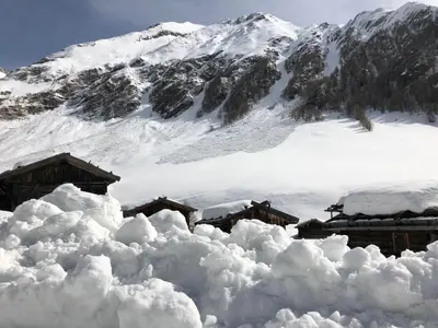 a pile of snow in front of a mountain at B&B Hotel Alpenrose Rooms & Apartments in Valles