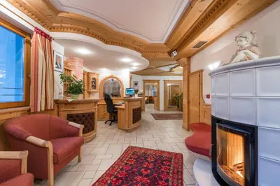 a living room with a fireplace and a desk at B&B Hotel Alpenrose Rooms & Apartments in Valles