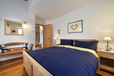 a bedroom with a blue bed and a mirror at Maso Vaia in Cavalese