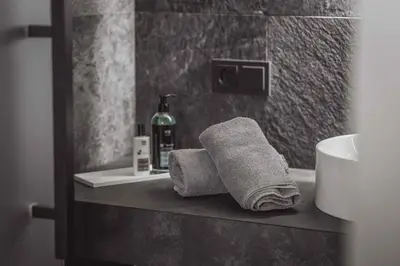 a bathroom with two towels and a bottle of soap at Hotel Continental Dolomites in Selva di Val Gardena