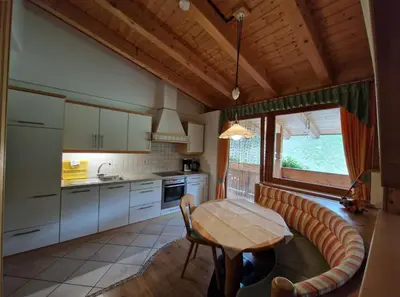 a kitchen with a wooden table and a table at Zollhof in Vipiteno
