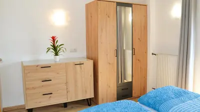 a bedroom with a wooden cabinet and a dresser at Residence Ferienwohnungen Sonnegg in Vollan
