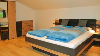 a bedroom with a bed with blue pillows on it at Residence Ferienwohnungen Sonnegg in Vollan