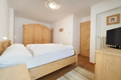 a bedroom with a bed and a flat screen tv at Appartamento Boschetto Giulia in Carano