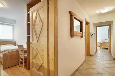 a hallway with a door and a bedroom at Appartamento Boschetto Giulia in Carano