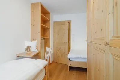 a bedroom with a bed and a desk and a closet at Appartamento Boschetto Giulia in Carano