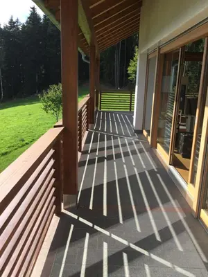 a front porch of a house with a wooden railing at Franzn Apartments in Petersberg