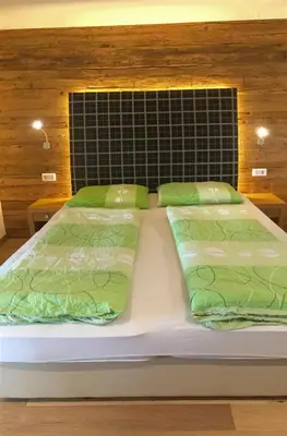 a bed with two green pillows on top of it at Franzn Apartments in Petersberg
