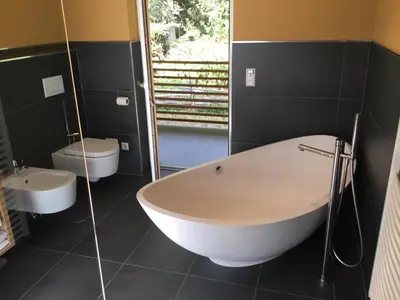 a bathroom with a large tub and a toilet at Franzn Apartments in Petersberg