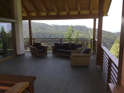 a screened in porch with couches and a view of the mountains at Franzn Apartments in Petersberg